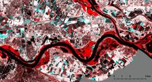 Gecombineerd satellietbeeld waarin de overstroomde gebieden in rood oplichten naast de zwarte rivier